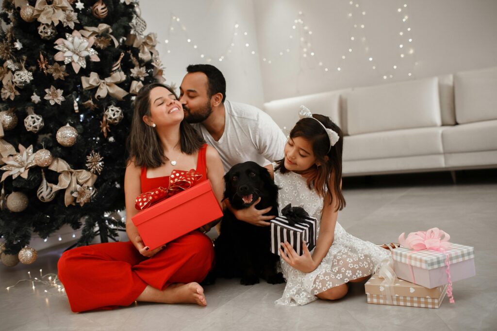 A family with a dog around a Christmas tree ready to open presents